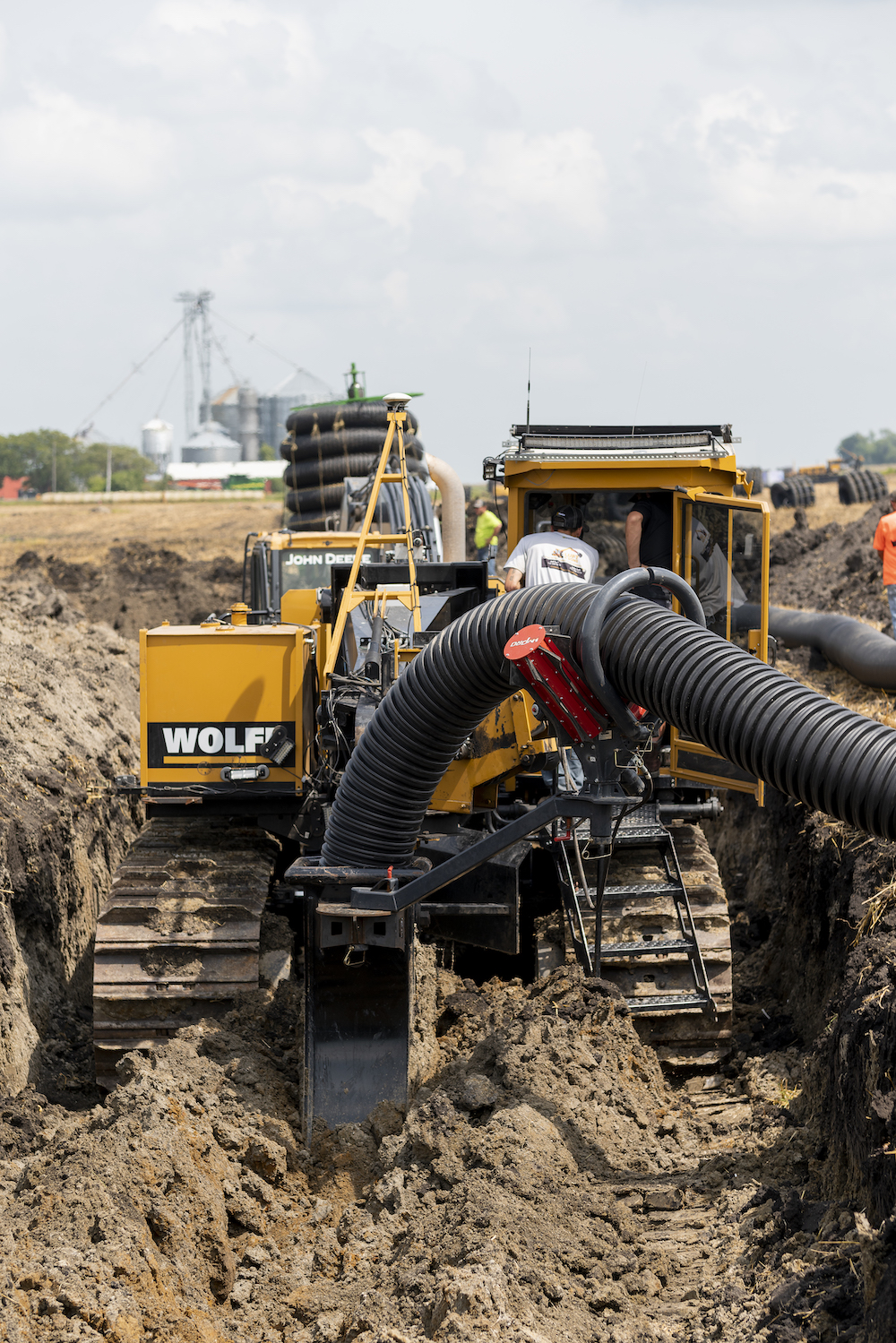 Luft and Sons laying drainage pipe on a customer's farm.
